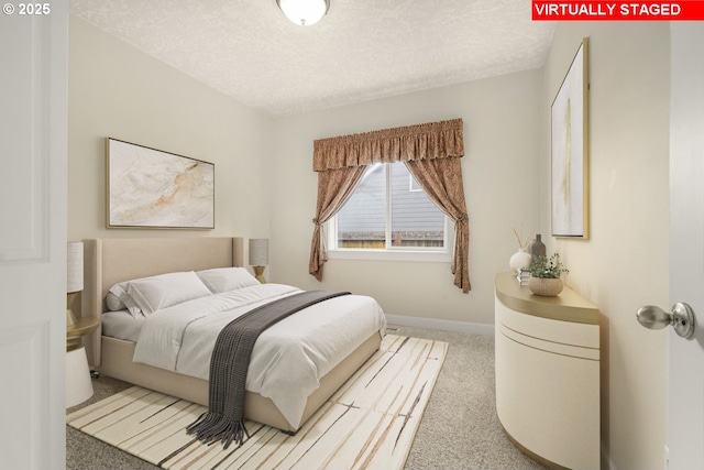 bedroom featuring carpet, a textured ceiling, and baseboards