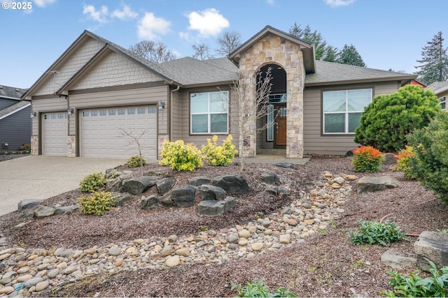 view of front of property featuring a garage, stone siding, driveway, and roof with shingles