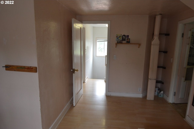 hallway with baseboards and light wood-type flooring
