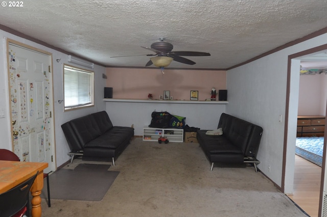 sitting room featuring a textured ceiling, ceiling fan, ornamental molding, and carpet flooring