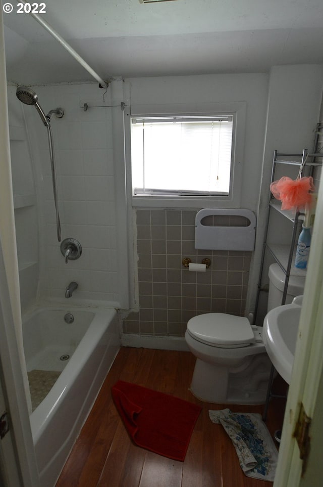 full bath with toilet, a sink,  shower combination, and wood finished floors