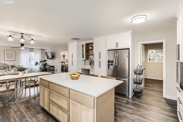 kitchen with stainless steel fridge with ice dispenser, a kitchen island, dark wood-type flooring, and ceiling fan