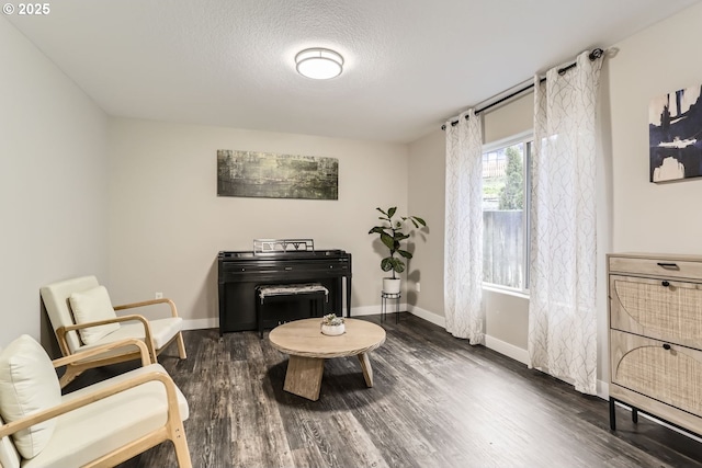 living area with a textured ceiling and dark wood-type flooring