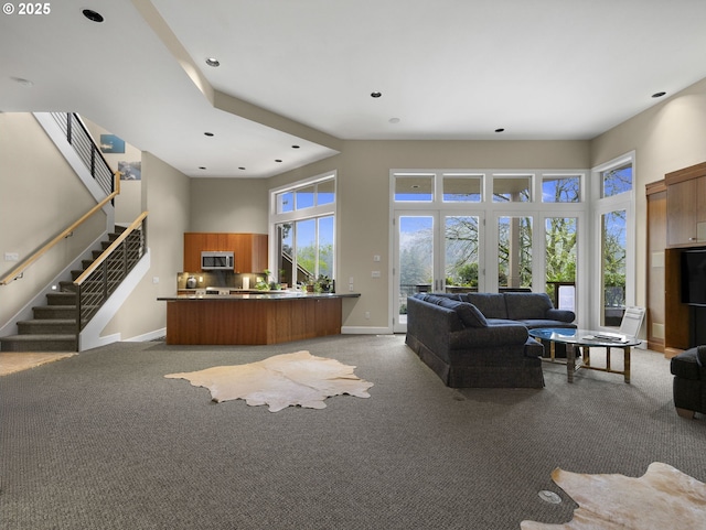 carpeted living room featuring a high ceiling