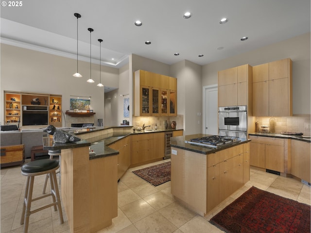 kitchen with pendant lighting, beverage cooler, a center island, and kitchen peninsula