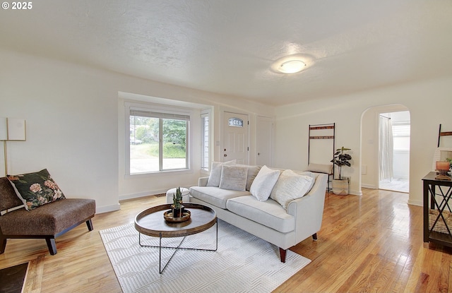 504 NW Fargo St, Camas, WA 98607 - living room featuring arched walkways, light wood-style floors, and baseboards