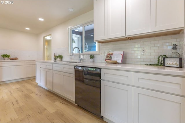 435 E 53rd Ave, Eugene, OR 97405 - kitchen featuring black dishwasher, light wood-style floors, white cabinets, light countertops, and backsplash