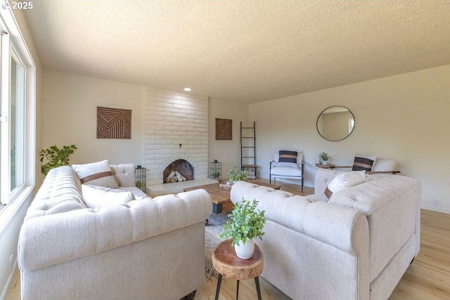 435 E 53rd Ave, Eugene, OR 97405 - living area with light wood finished floors, a textured ceiling, a brick fireplace, and plenty of natural light