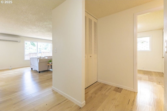 435 E 53rd Ave, Eugene, OR 97405 - hallway featuring a wall unit AC, light wood-type flooring, and a textured ceiling
