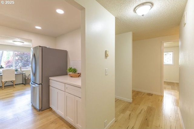 435 E 53rd Ave, Eugene, OR 97405 - kitchen featuring freestanding refrigerator, light wood-type flooring, white cabinets, and healthy amount of natural light