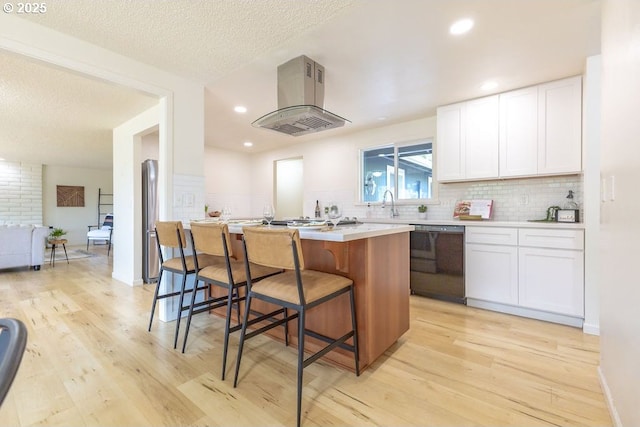 435 E 53rd Ave, Eugene, OR 97405 - kitchen featuring dishwasher, island range hood, light wood-style floors, a kitchen bar, and white cabinets