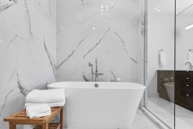 bathroom with vanity, a bathtub, and tile walls