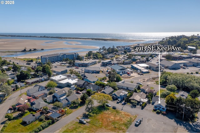 birds eye view of property featuring a water view and a beach view