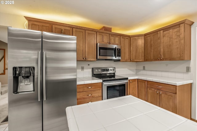 16620 SE Ladd Ct, Milwaukie, OR 97267 - kitchen featuring appliances with stainless steel finishes, brown cabinetry, and tile countertops