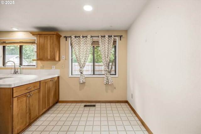16620 SE Ladd Ct, Milwaukie, OR 97267 - kitchen with tile countertops, recessed lighting, brown cabinetry, and light tile patterned flooring