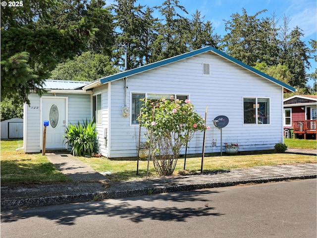 125 SW Cedar Ave, Warrenton, OR 97146 - view of front facade featuring a storage shed, a metal roof, and a front yard