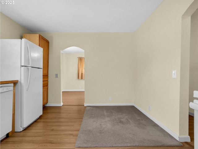 125 SW Cedar Ave, Warrenton, OR 97146 - kitchen with white appliances, arched walkways, light wood-style floors, and brown cabinets