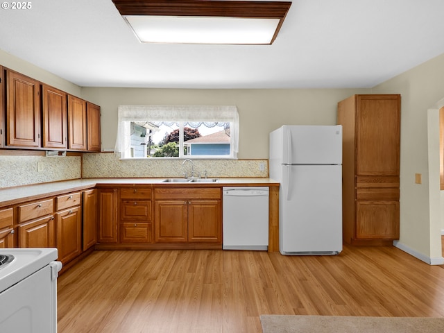 125 SW Cedar Ave, Warrenton, OR 97146 - kitchen featuring white appliances, brown cabinets, light wood finished floors, and decorative backsplash