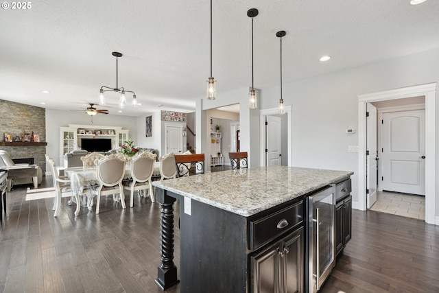 132 N 39th Ct, Ridgefield, WA 98642 - kitchen with beverage cooler, a ceiling fan, dark wood-style flooring, a kitchen bar, and recessed lighting