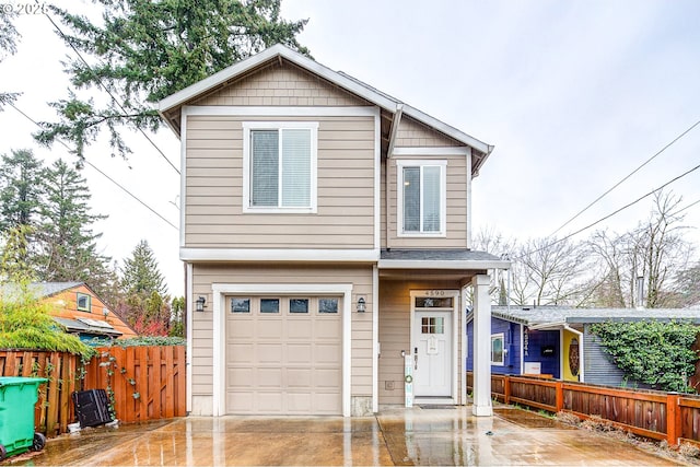 view of front of property with concrete driveway, an attached garage, and fence