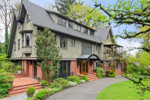 1965 SW Montgomery Pl, Portland, OR 97201 - view of front facade with stucco siding, brick siding, a chimney, and a shingled roof
