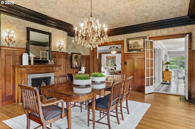 1965 SW Montgomery Pl, Portland, OR 97201 - dining room with crown molding, a chandelier, light wood-style flooring, a wainscoted wall, and a high end fireplace