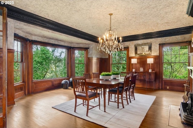 1965 SW Montgomery Pl, Portland, OR 97201 - dining room featuring a chandelier, wood finished floors, plenty of natural light, ornamental molding, and wainscoting