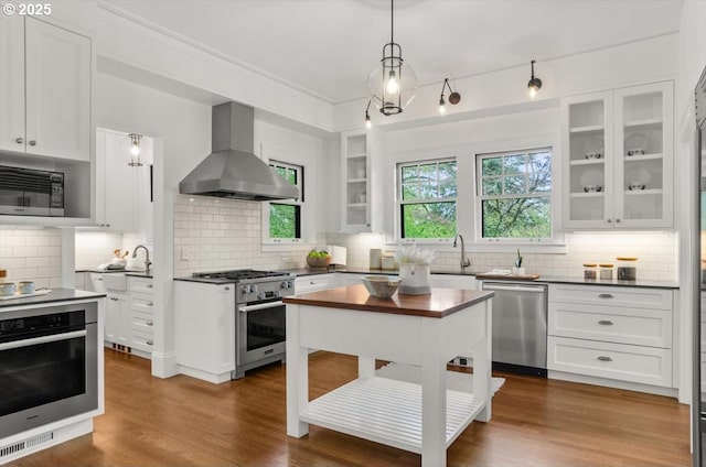 1965 SW Montgomery Pl, Portland, OR 97201 - kitchen with stainless steel appliances, extractor fan, backsplash, and white cabinetry