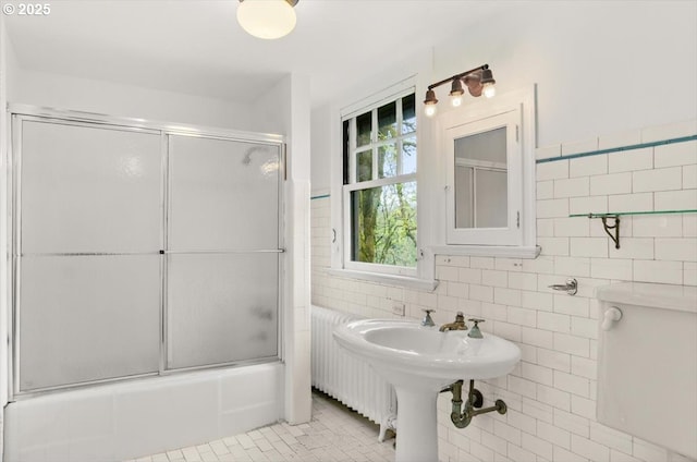 1965 SW Montgomery Pl, Portland, OR 97201 - bathroom featuring tile walls, bath / shower combo with glass door, radiator, a sink, and tile patterned flooring