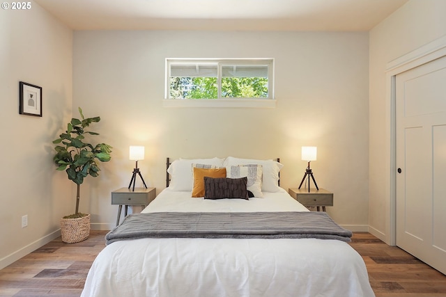 bedroom featuring baseboards and wood finished floors