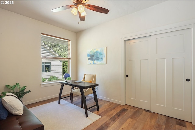 office space featuring light wood-style floors, baseboards, and ceiling fan