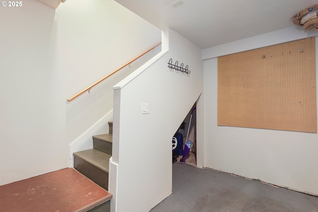 stairs featuring unfinished concrete floors