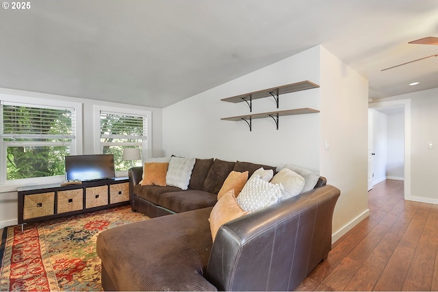 living area with baseboards, hardwood / wood-style floors, a ceiling fan, and lofted ceiling