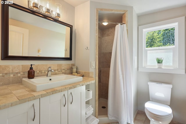 bathroom featuring toilet, vanity, decorative backsplash, and a shower stall