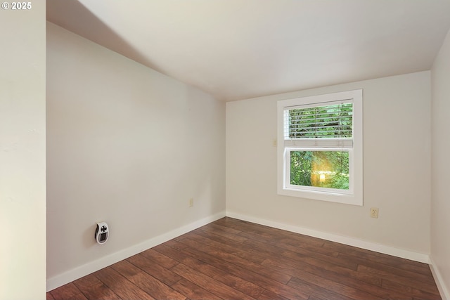 spare room featuring dark wood finished floors and baseboards