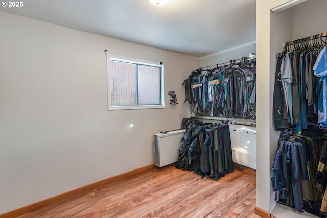 walk in closet with light hardwood / wood-style flooring