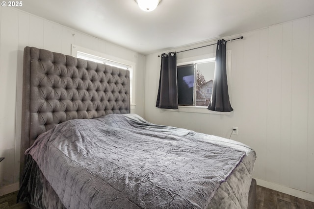 bedroom featuring dark hardwood / wood-style flooring and wood walls