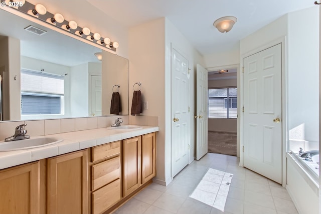 bathroom featuring tile patterned flooring, visible vents, a sink, and double vanity