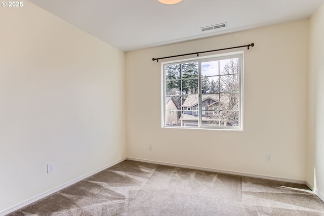 unfurnished room featuring carpet, visible vents, and baseboards