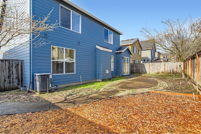 back of house featuring a fenced backyard, cooling unit, and a patio