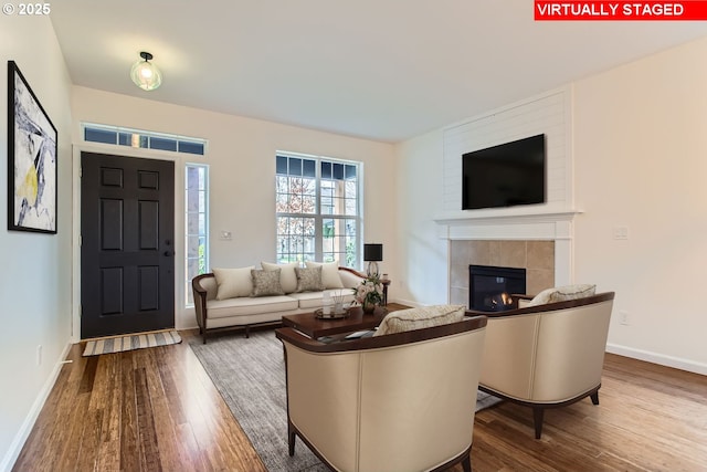 living room with a fireplace, wood finished floors, and baseboards