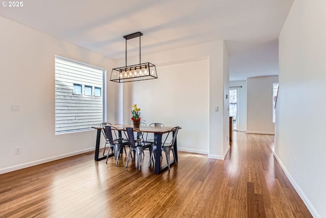 dining space featuring wood finished floors and baseboards