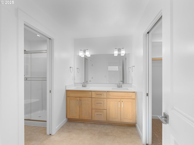 bathroom with vanity and a shower with door