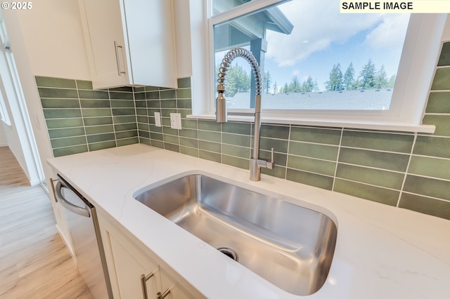 1496 NE Josephine Ct Unit 181, Estacada, OR 97023 - kitchen view of a sink, light stone counters, white cabinetry, tasteful backsplash, and dishwasher
