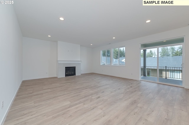1496 NE Josephine Ct Unit 181, Estacada, OR 97023 - unfurnished living room with light wood-type flooring, recessed lighting, baseboards, and a glass covered fireplace