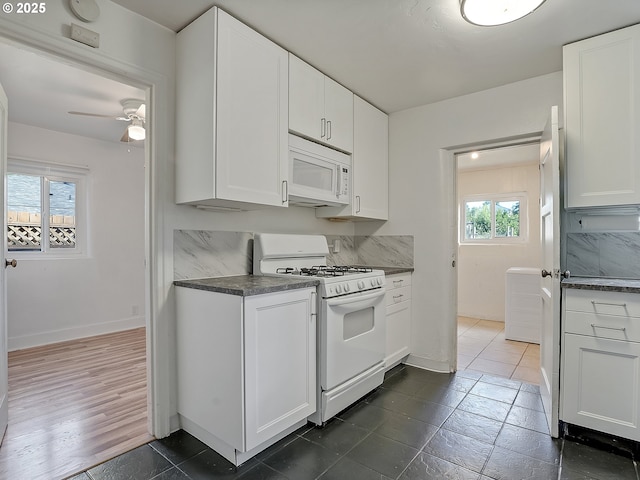 12226 SE Raymond St, Portland, OR 97236 - kitchen featuring white appliances, dark countertops, ceiling fan, white cabinets, and baseboards