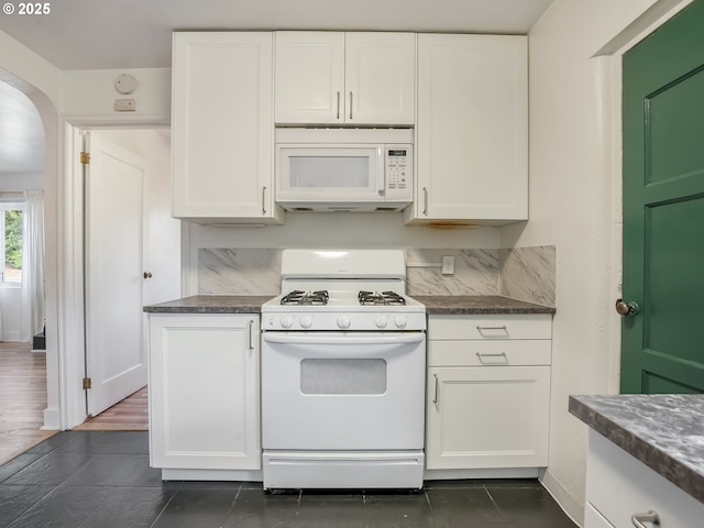 12226 SE Raymond St, Portland, OR 97236 - kitchen with white appliances, white cabinets, dark countertops, and arched walkways