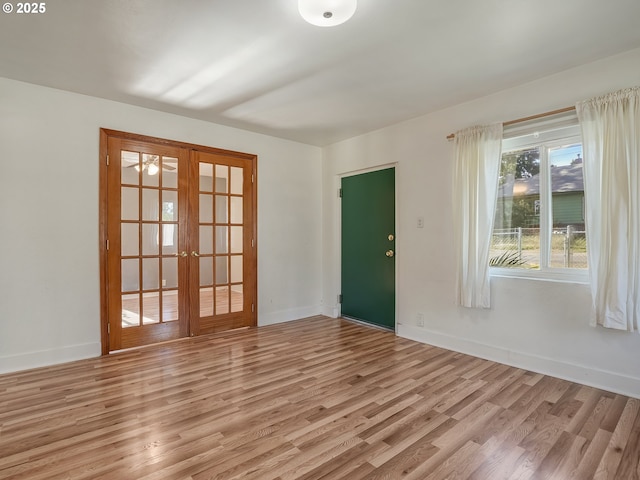 12226 SE Raymond St, Portland, OR 97236 - spare room featuring french doors, light wood-style floors, and baseboards