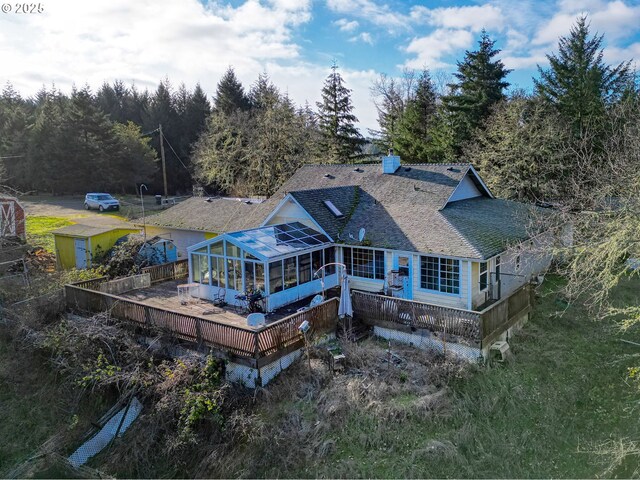 back of house featuring a wooden deck and a sunroom