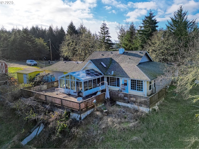 rear view of property featuring a deck and a sunroom